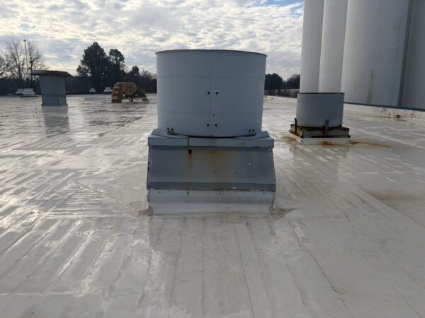 Rooftop ventilation units on white flat roof