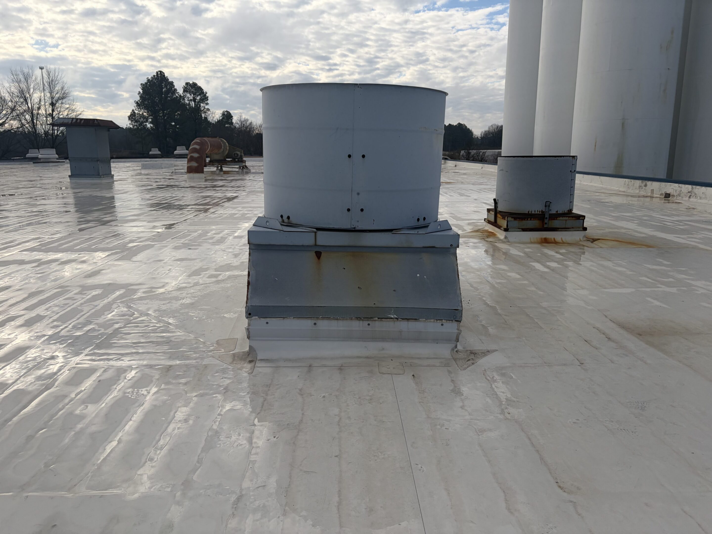 Rooftop ventilation units on white flat roof