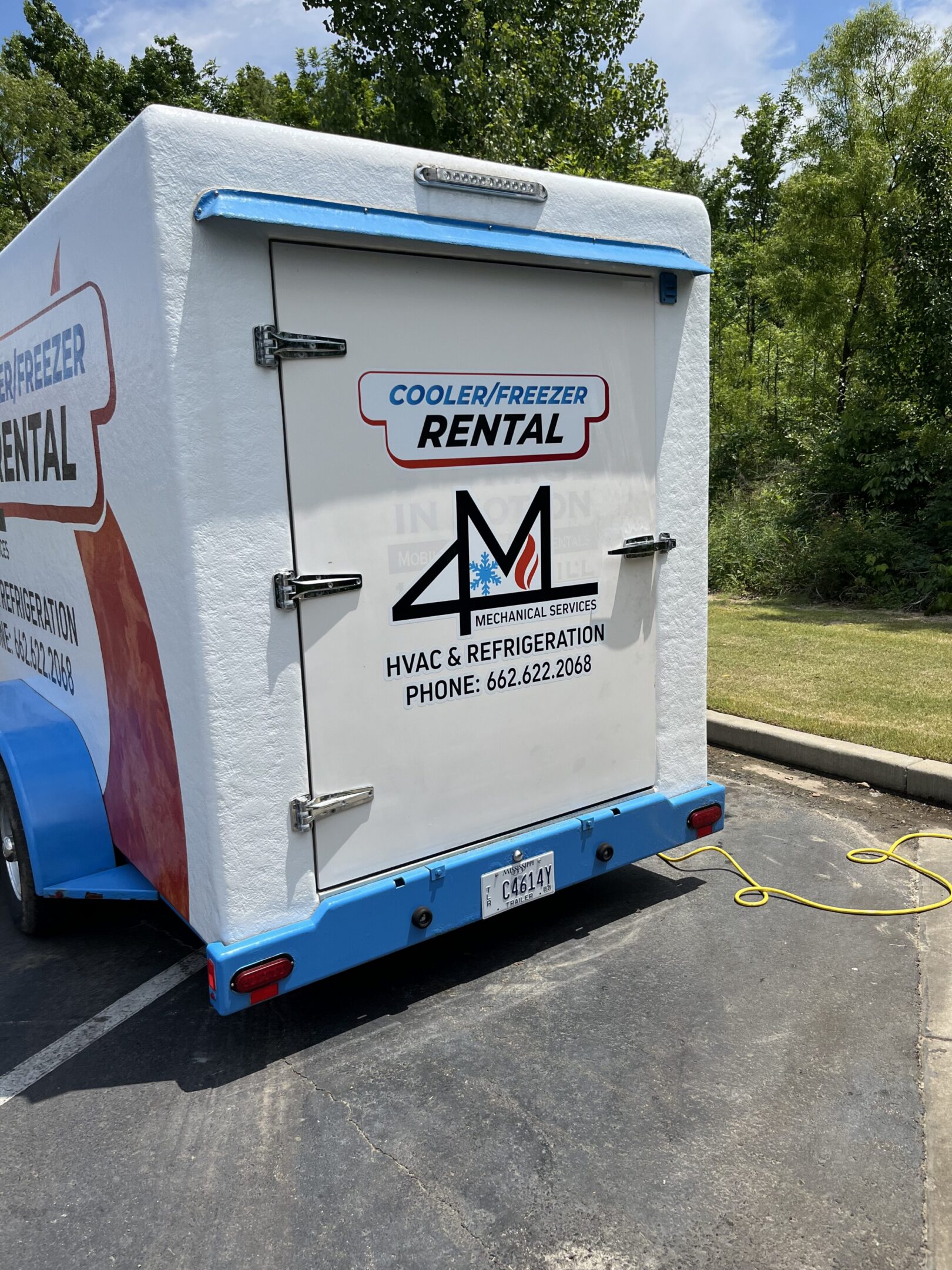 White cooler/freezer rental trailer in parking lot